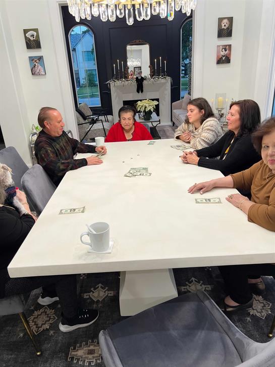 Several family members are seated at a large dining table enjoying each other's company.