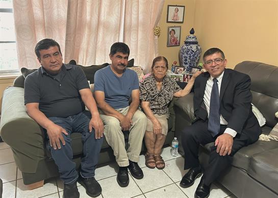 Four family members sit comfortably in their living room, sharing smiles and stories.