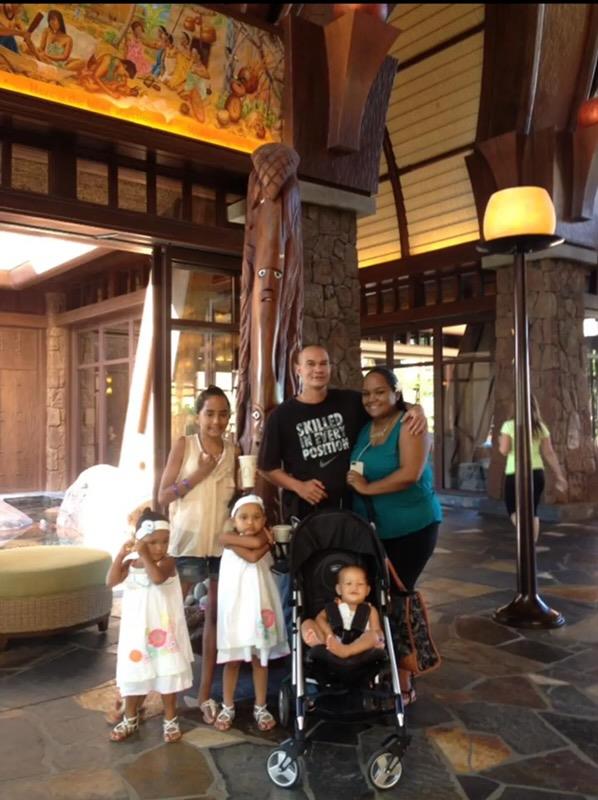 A family poses together in a luxurious lobby filled with cultural artwork and decorations.