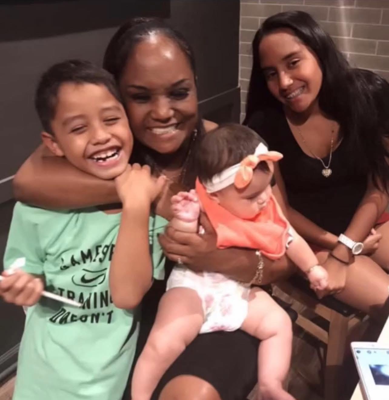 Four family members share laughs and smiles while celebrating a special occasion at home.