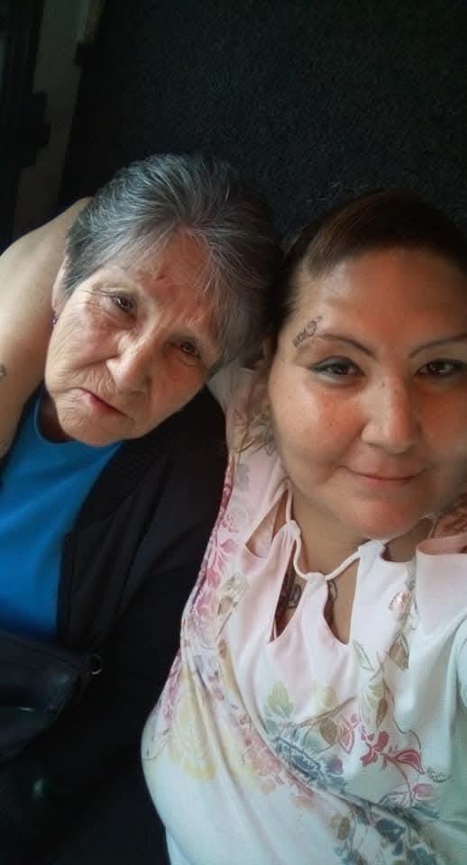 Two women enjoy each other's company, embracing and smiling while taking a close selfie.