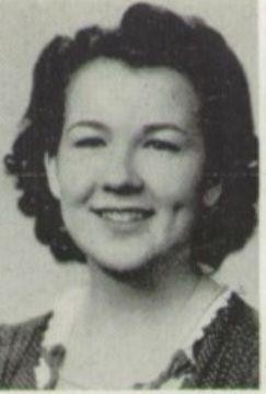 A young woman with curly hair smiles warmly in a vintage portrait from a past era.