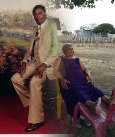 An elderly couple relaxes together outdoors, sharing stories in a warm, sunny atmosphere.