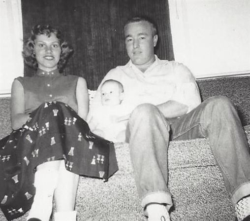 A man and woman sitting on stairs with a baby