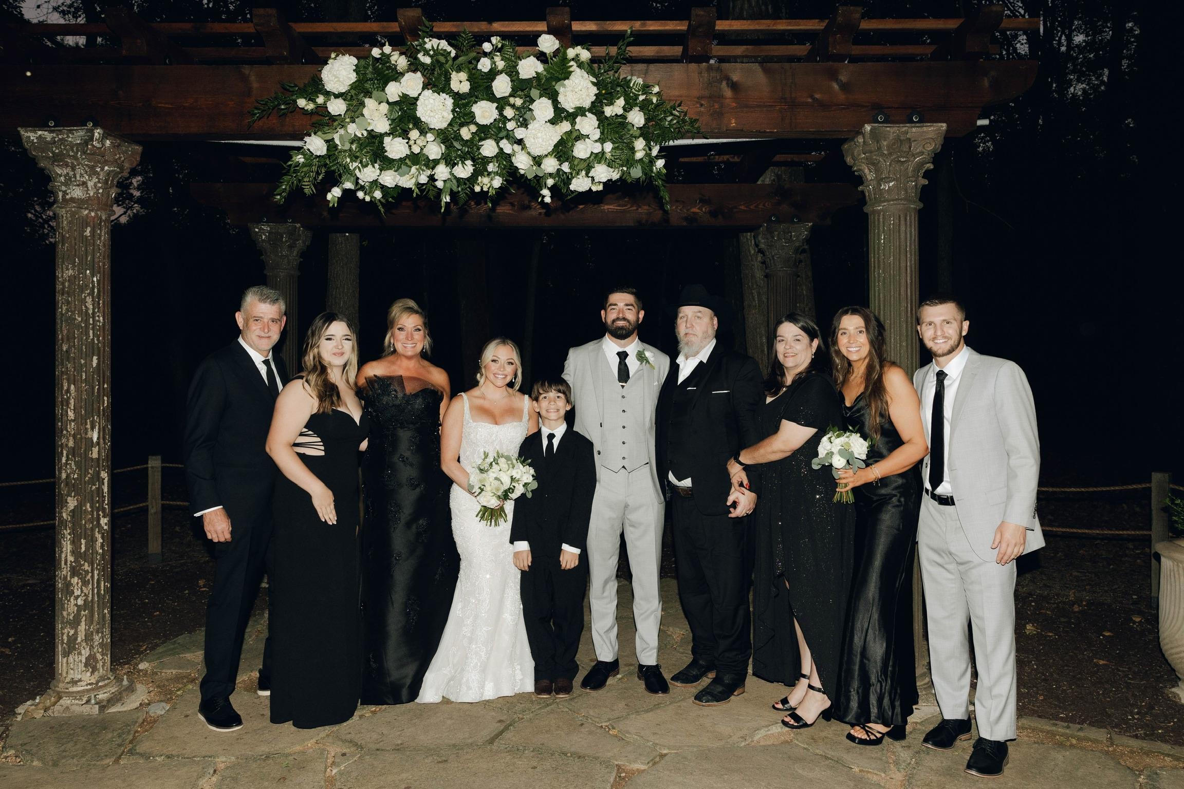 A joyful gathering of guests celebrating a wedding at a beautifully decorated outdoor venue.