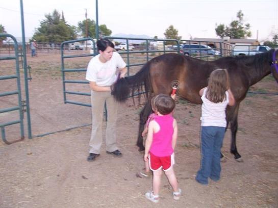 A woman and children standing next to a horse