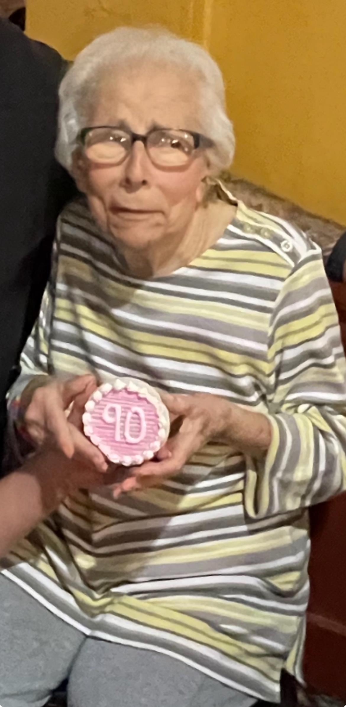 Family gathers to celebrate a milestone birthday with cake and heartfelt moments of joy.