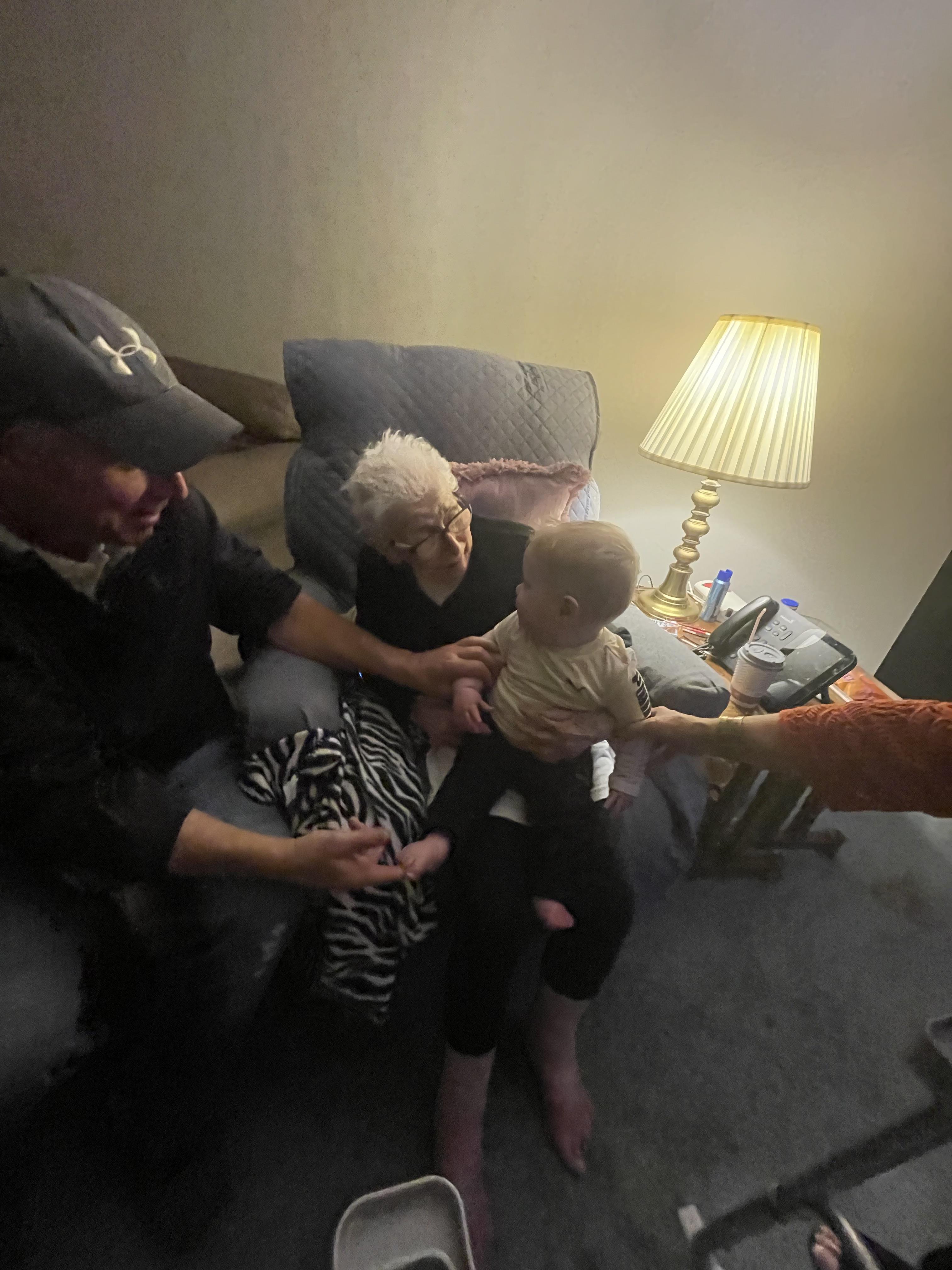Grandparents enjoy quality time with their grandchild in a welcoming living room setting.