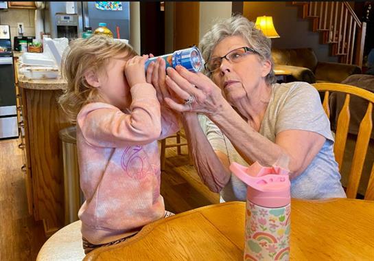 An older woman and a young girl playing with a can