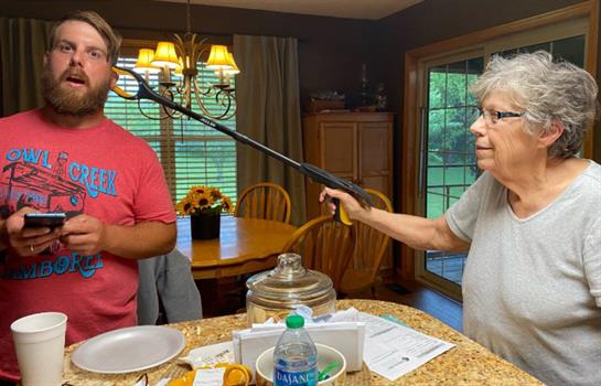 A man holding a gun to a woman's face