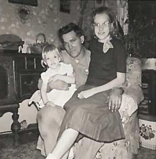 A man and two girls sitting on a chair