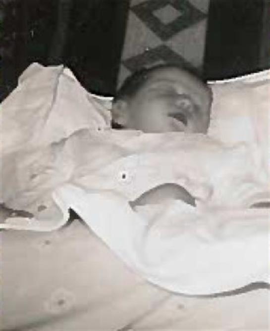 A baby lying in a white blanket