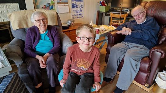 Family members relax together in a warm, inviting living space while sharing joyful moments.