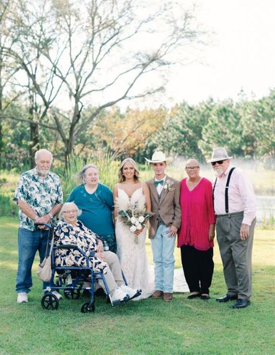 A family poses together after a wedding ceremony in a beautiful natural setting.