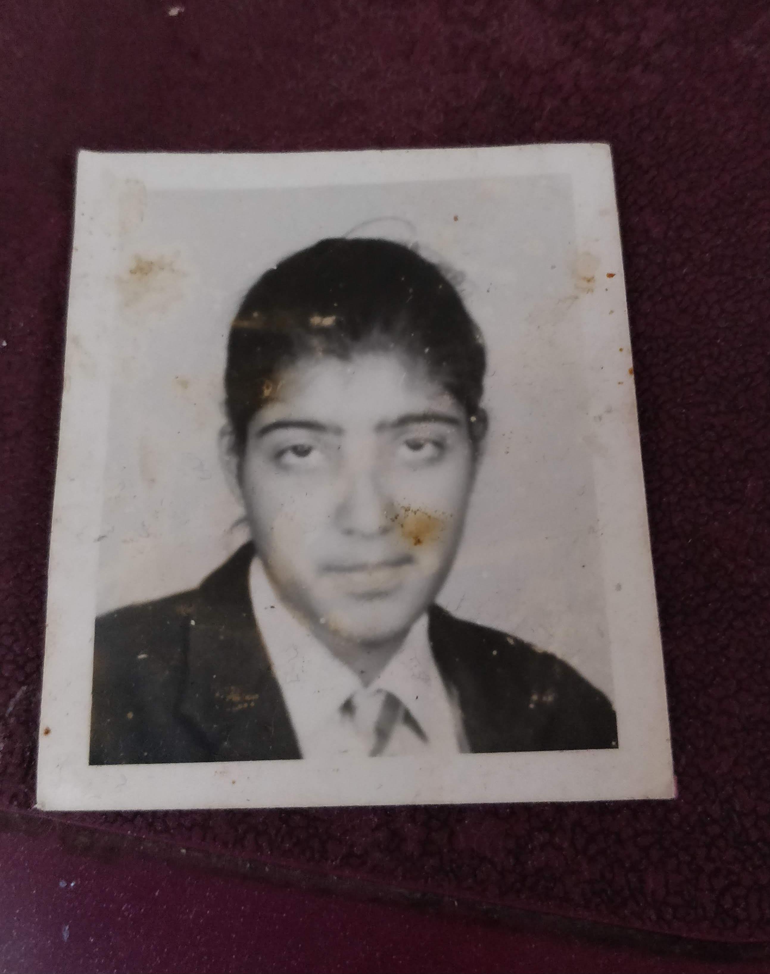 A young man is dressed in formal attire, showcasing a thoughtful expression and hairstyle.