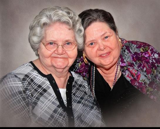 Two joyful elderly women pose closely, expressing their deep friendship and happiness.