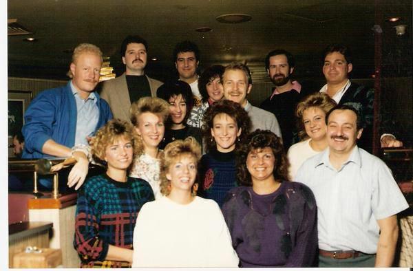 Friends gather together smiling and celebrating at a restaurant, enjoying a memorable moment.