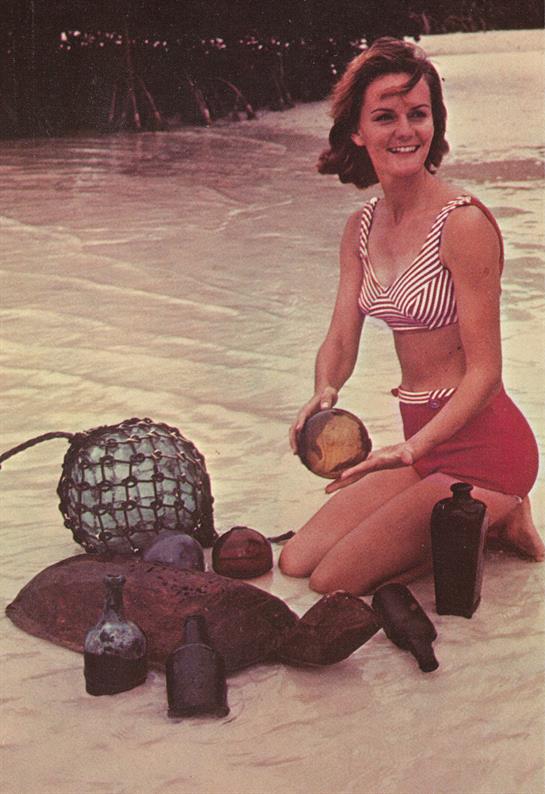 A woman in a bathing suit holding a glass object