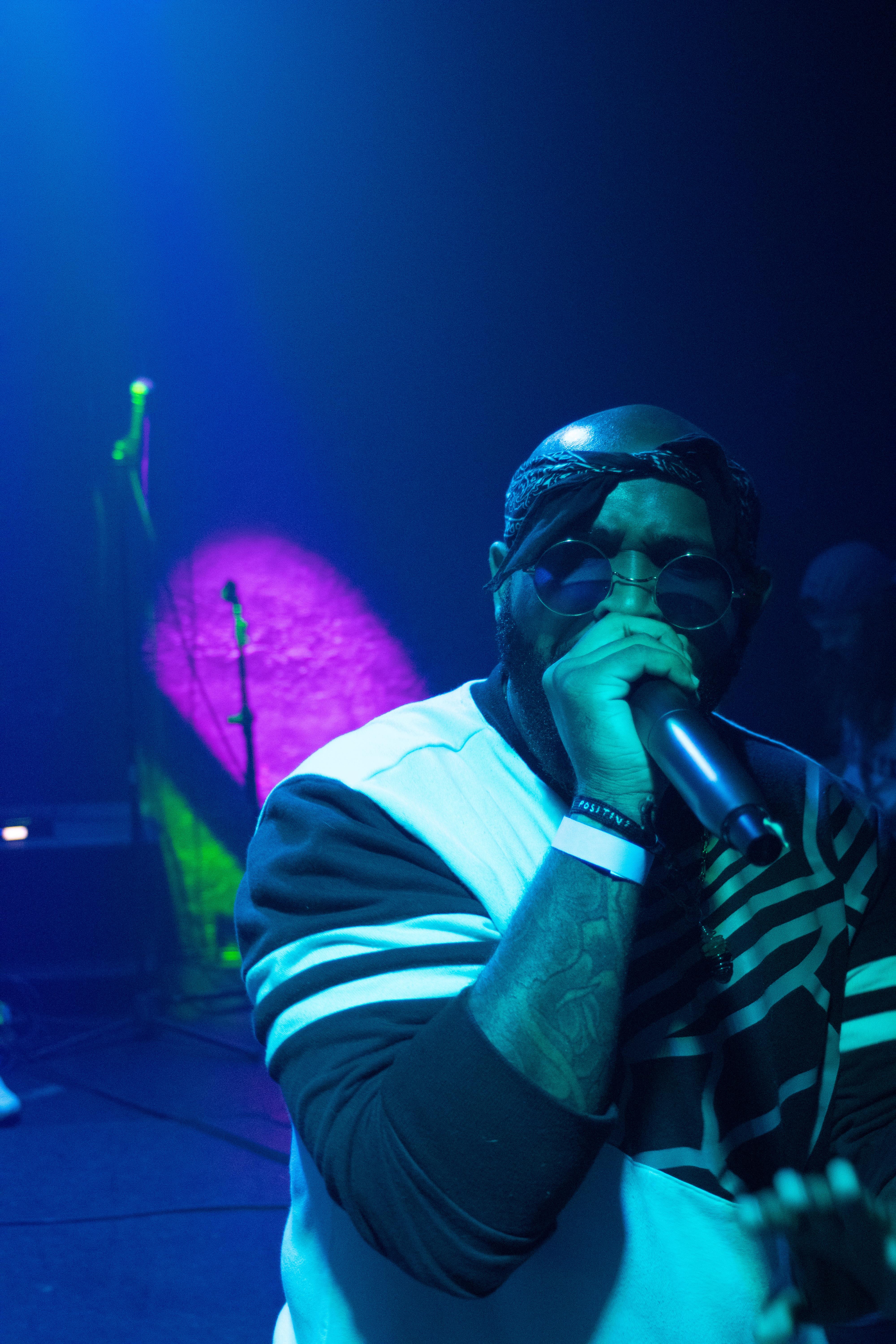 The artist passionately performs on stage, engaging the crowd in an energetic atmosphere.