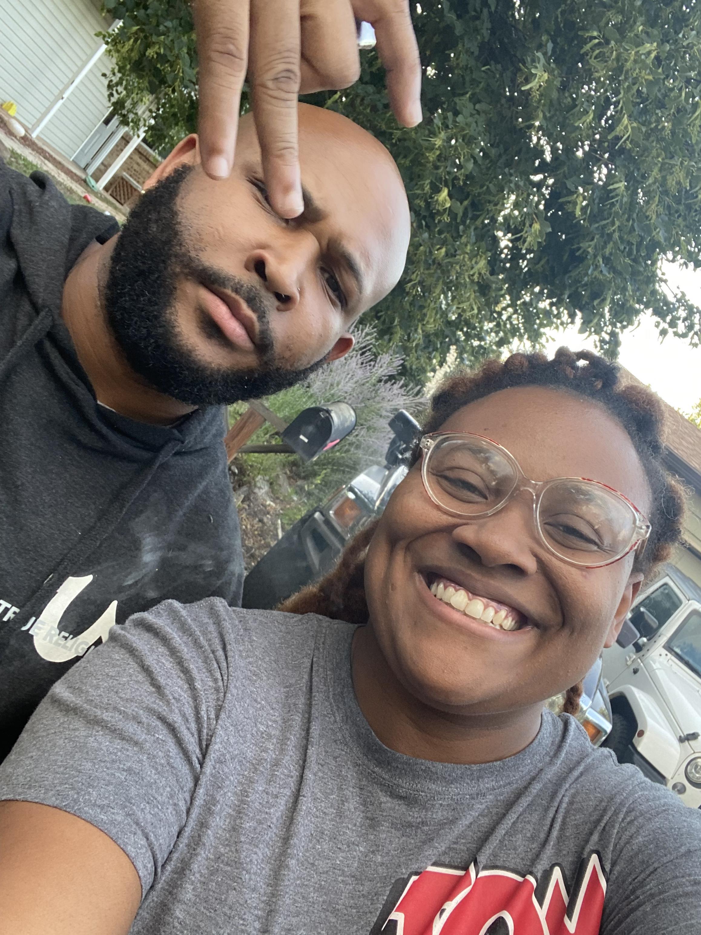 Two friends take a cheerful selfie outdoors, showcasing their playful expressions and camaraderie.