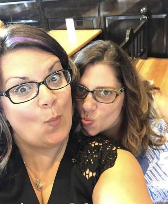 Friends enjoy a lighthearted moment, posing playfully for a selfie at a local eatery.