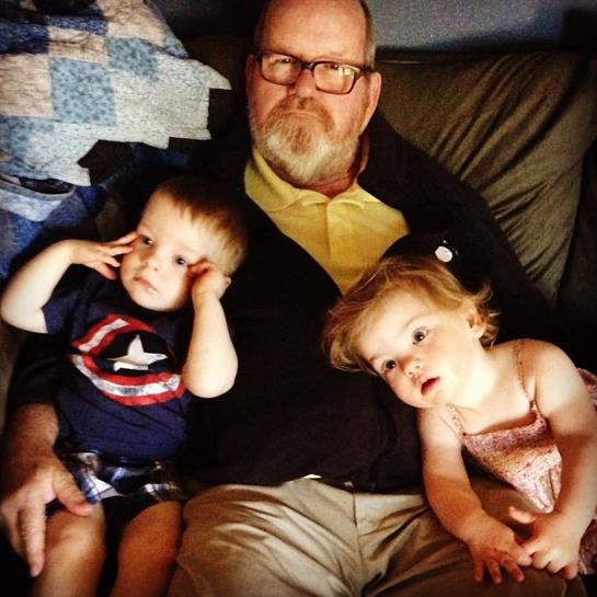A man and two children sitting on a couch