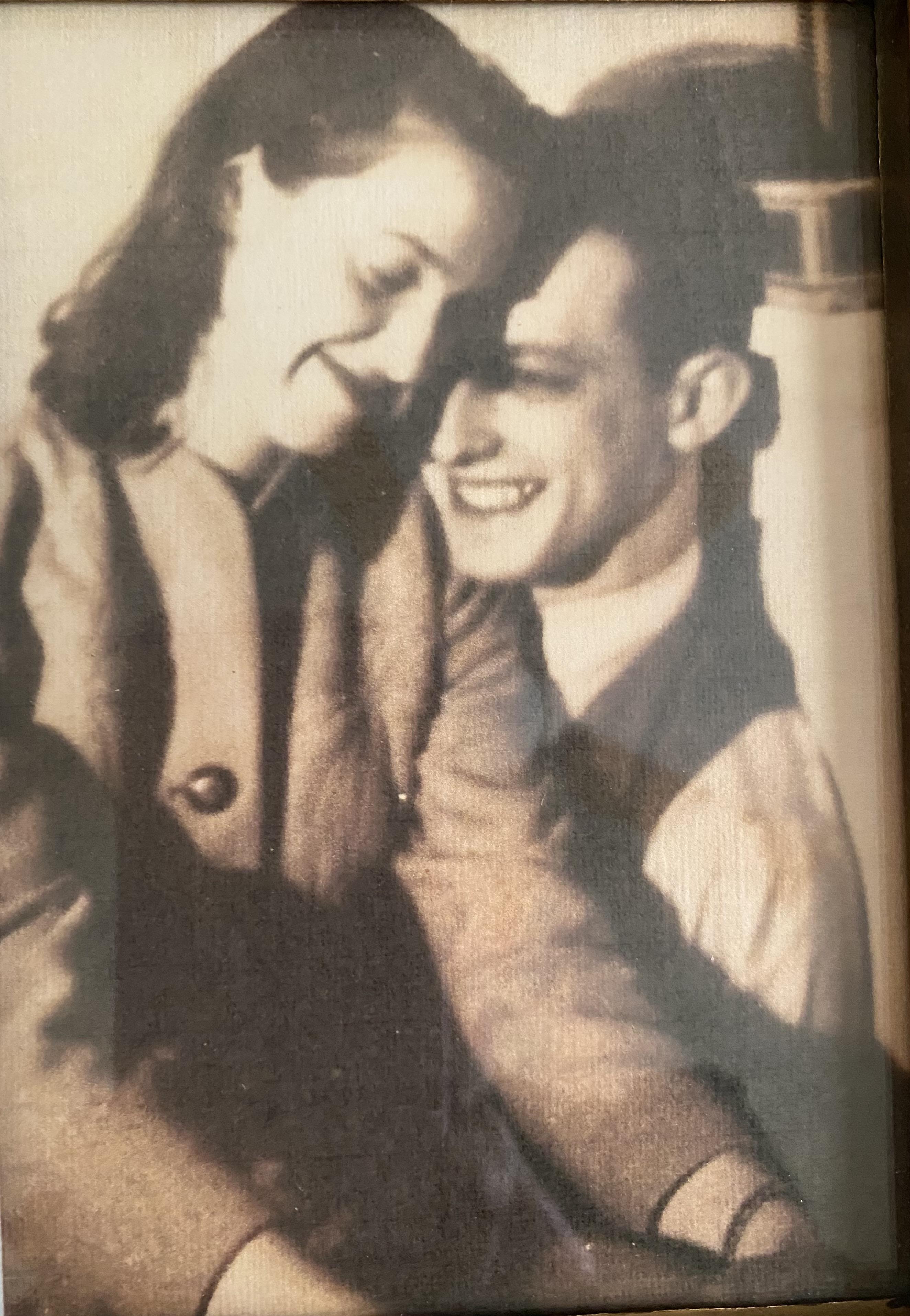 Two people share a warm embrace and smile at each other in a charming indoor environment.
