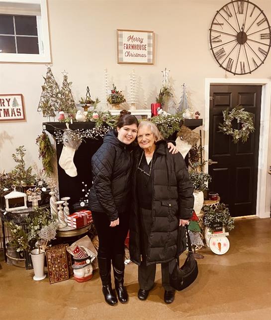 Two women standing in front of a fireplace