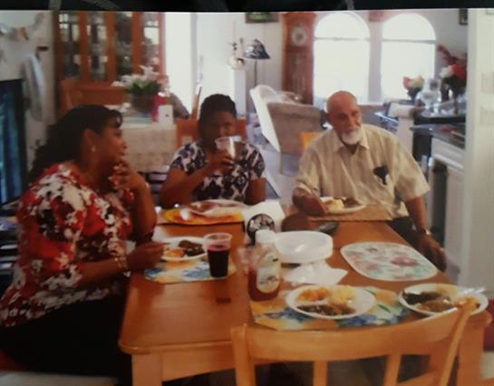 Friends and family gather around a dining table sharing homemade meals and laughter.