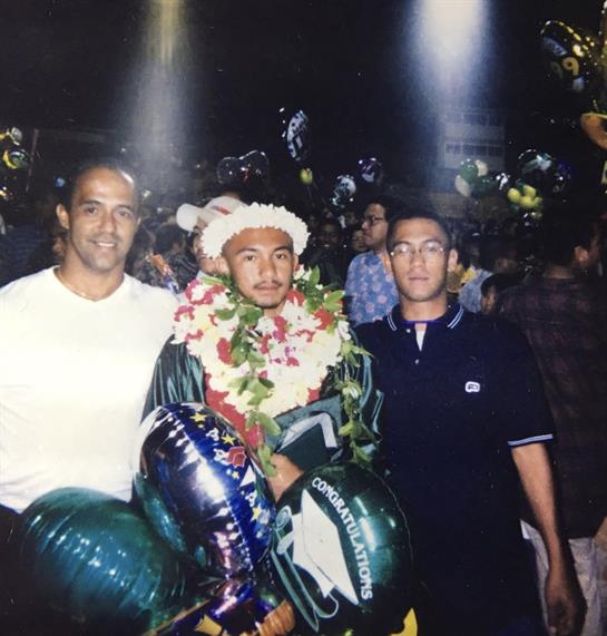 Friends gather around a recently honored athlete, surrounded by balloons and festivities.