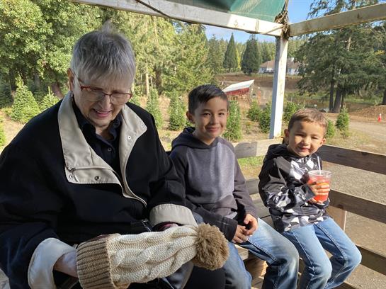 A woman and two boys sitting on a bench