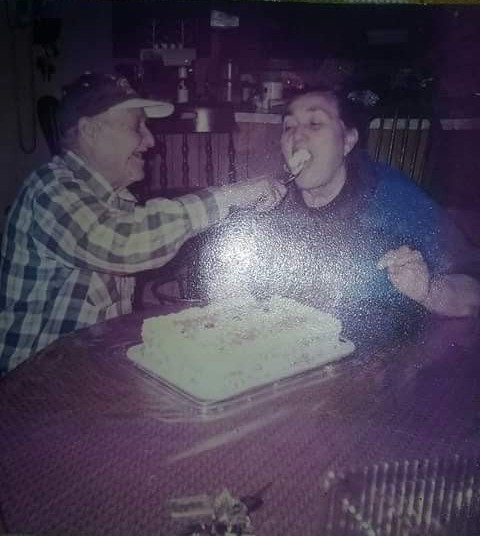A man feeding a woman with a cake