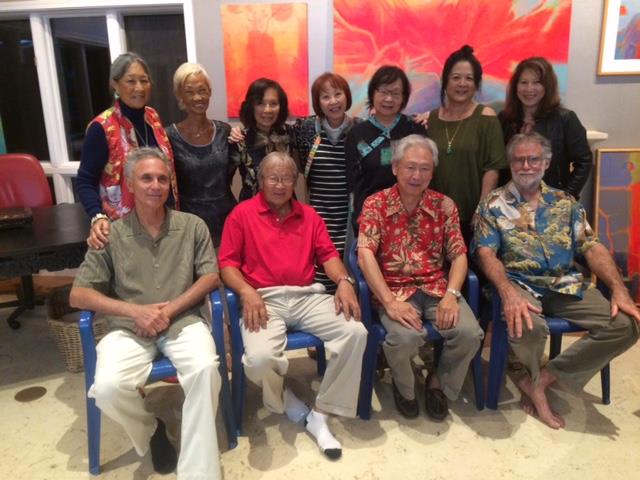 A diverse group of friends joyfully reunites in a colorful, relaxed indoor space.