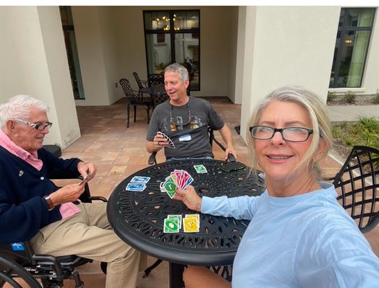 A group of people sitting at a table playing cards