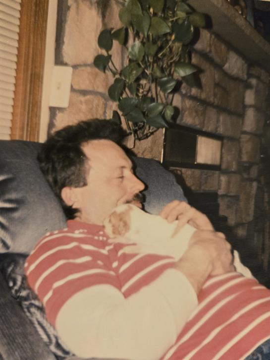 A man lying on a couch holding a cat