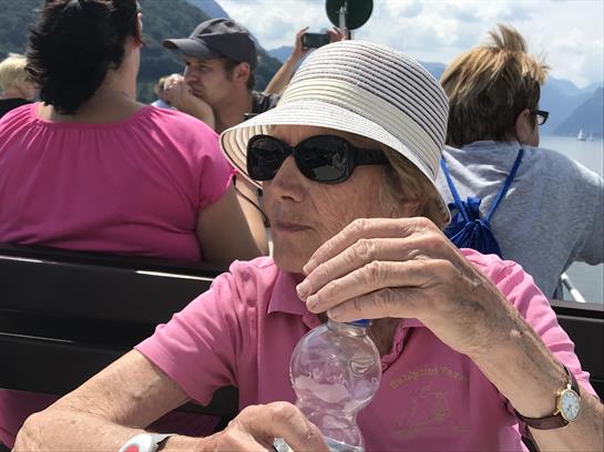 A woman wearing a hat and sunglasses holding a bottle of water