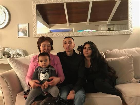 A family is gathered together on a comfortable couch, sharing smiles and laughter.