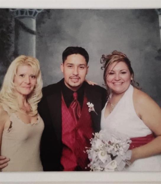 Three friends embrace happily, dressed for a formal celebration, capturing a moment of joy.