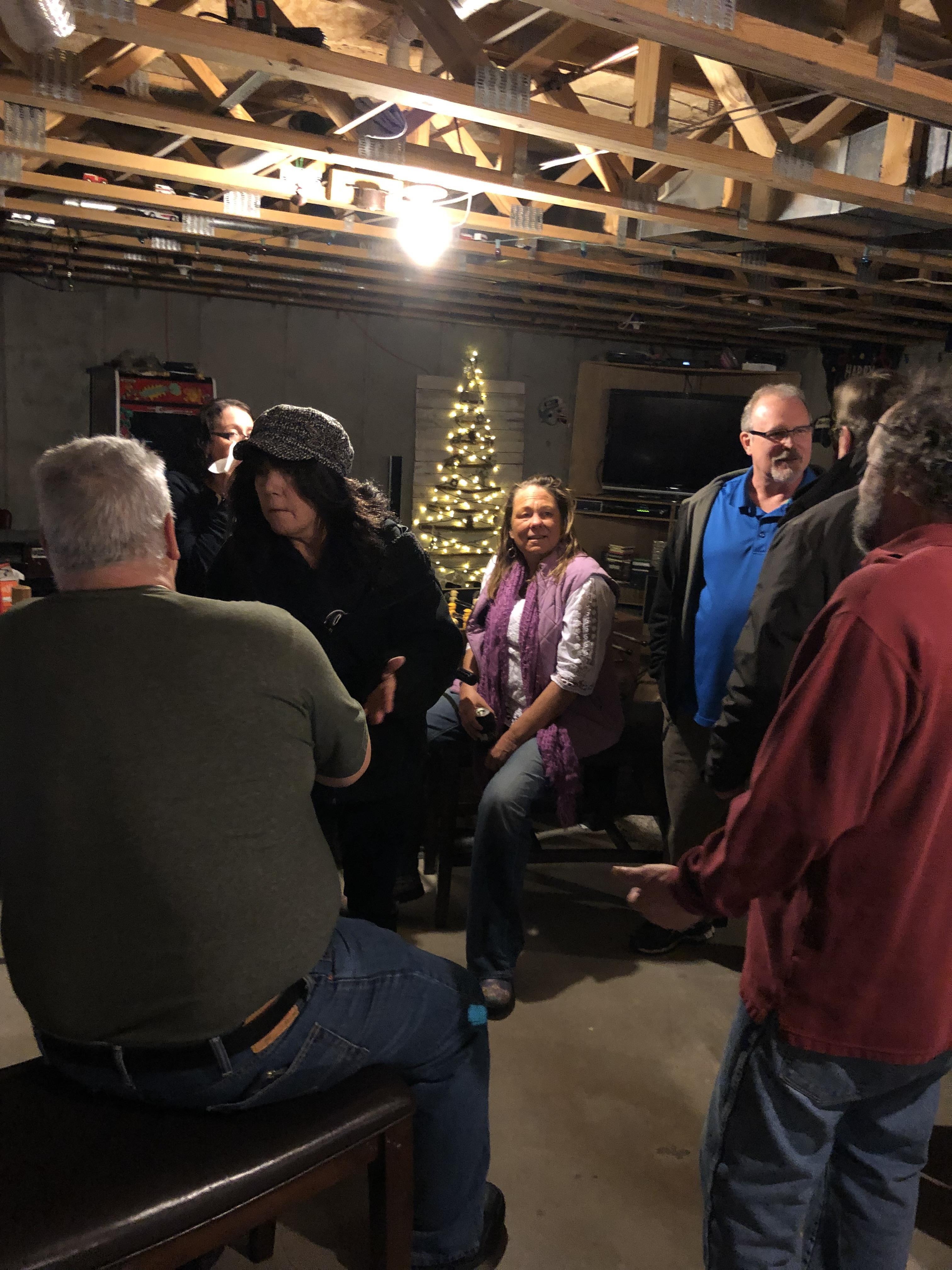 A joyful group of relatives enjoying camaraderie in a warmly decorated basement.