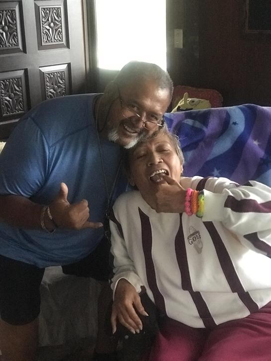 An elderly couple share laughter and happiness in their comfortable living room, creating memories.
