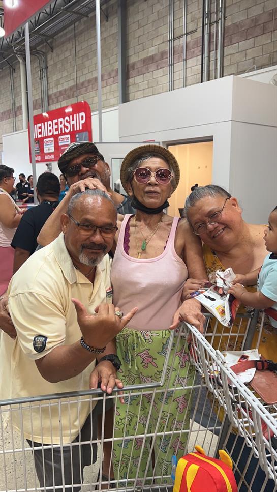 Family members interact happily while shopping in a warehouse store, creating joyful memories.
