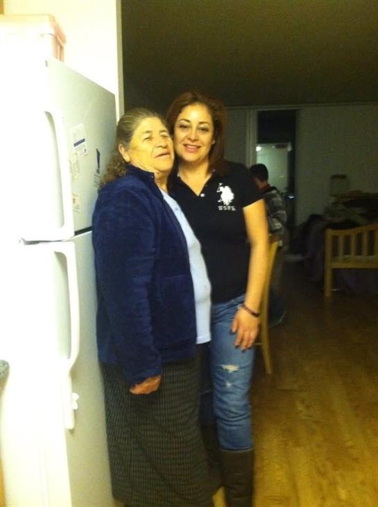 Two women share a warm moment in a kitchen, enjoying family time together in the evening.