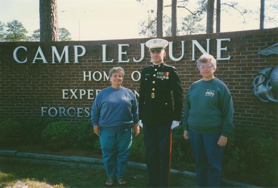 A man in uniform standing in front of a sign