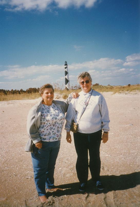Two women standing in the sand
