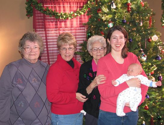 A group of women standing in front of a christmas tree