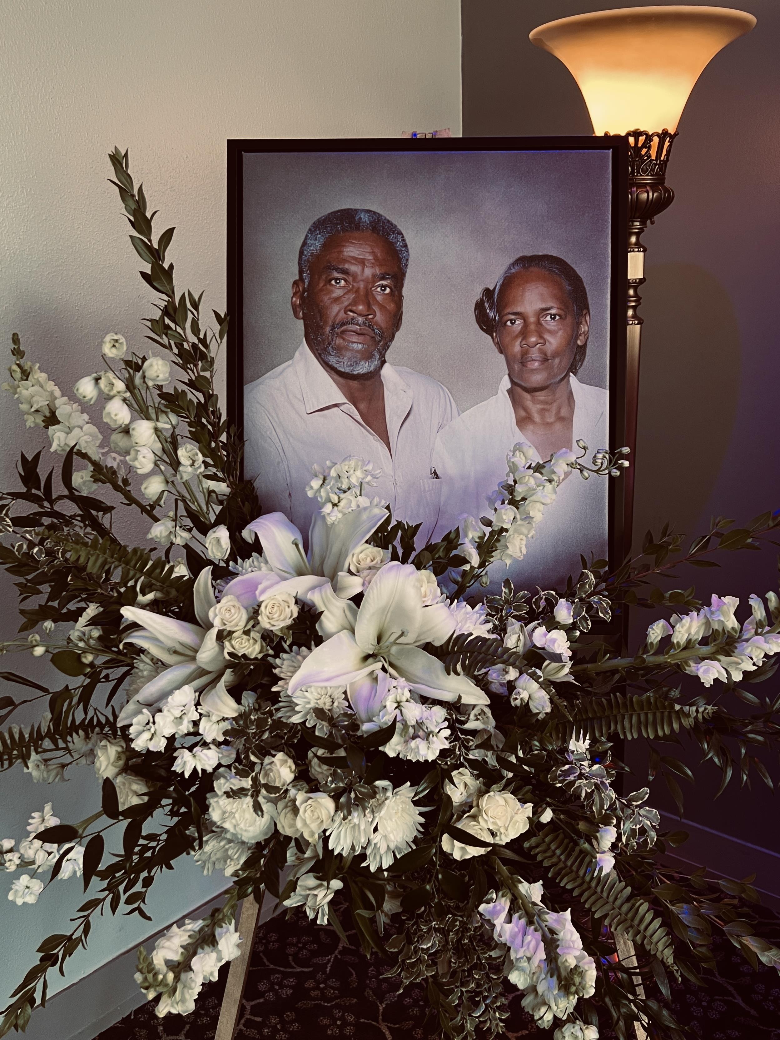 A lovely display of white flowers framing a couple's portrait in warm light.