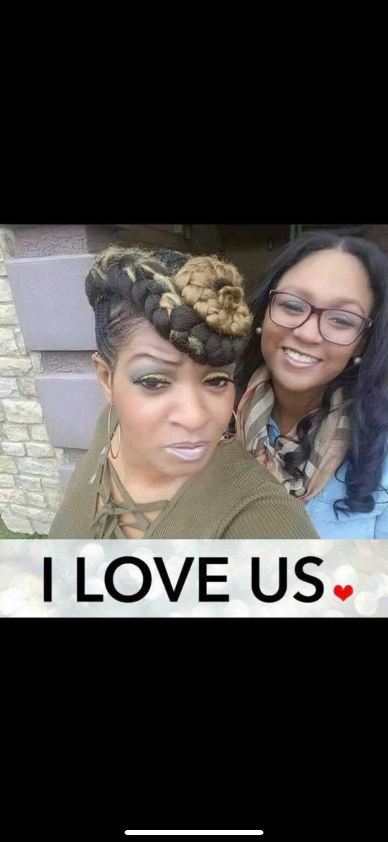 Two women pose happily together, radiating friendship and affection in a warm atmosphere.