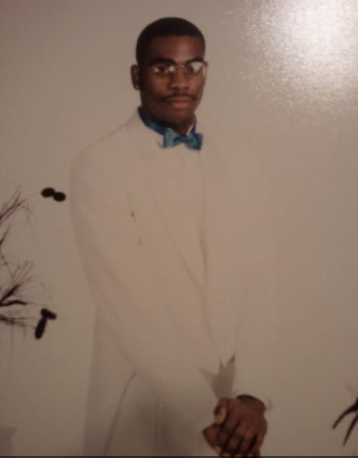 A well-dressed man stands confidently, highlighting elegance and fashion in formal attire.