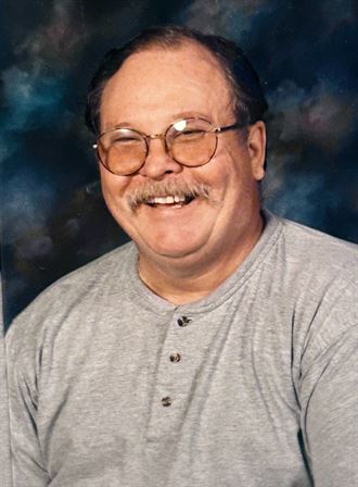A man wearing glasses and smiling