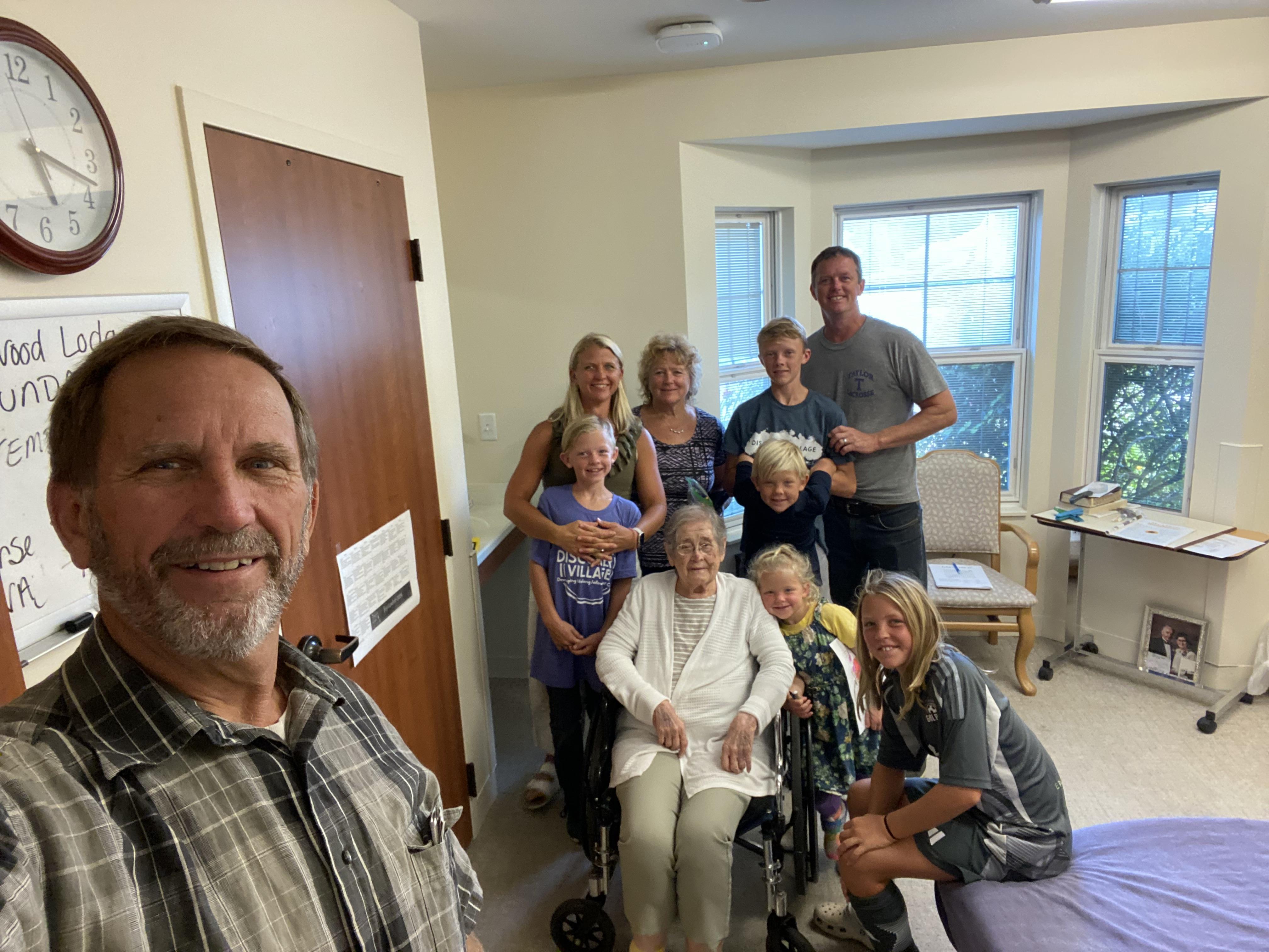 Family members happily gather in a care facility room, cherishing precious moments.